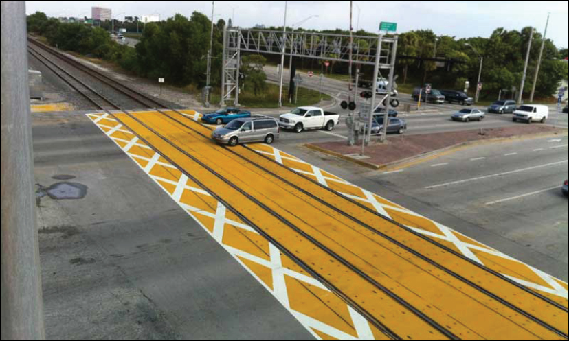 A pedestrian crossing area indicted with yellow paint and raised material